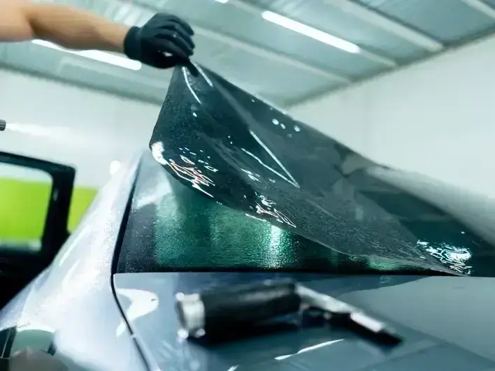 technician fixing a rock chip windshield in Downtown Edmonds with light rain on the glass